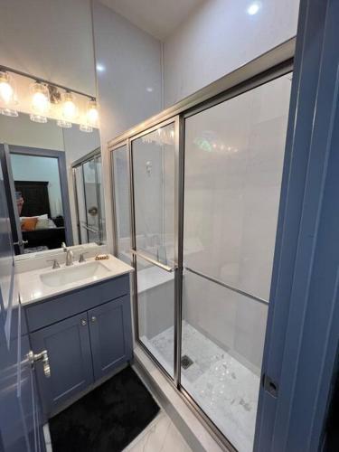 a bathroom with a shower and a sink and a mirror at Perfectly located 2 bed/2 full bathroom/1 sofa bed in Bentonville