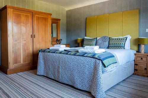 a bedroom with a large bed with blue and white sheets at The Inn on the Moor Hotel in Goathland