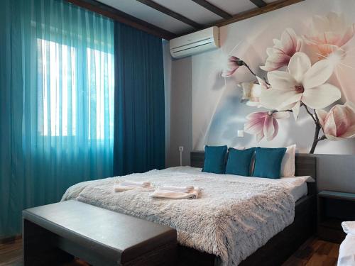 1 dormitorio con 1 cama grande con flores en la pared en Asya Guest House, en Sapareva Banya