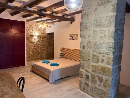 1 dormitorio con cama y pared de piedra en Antiguo Molino en Arnes