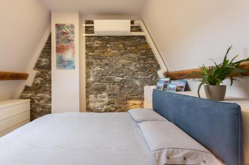 a bed in a room with a stone wall at Castello Ripa Baveno in Baveno