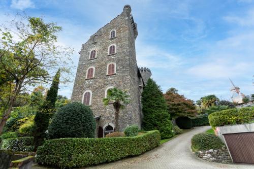 una vista exterior de una torre de piedra en un jardín en Castello Ripa Baveno, en Baveno