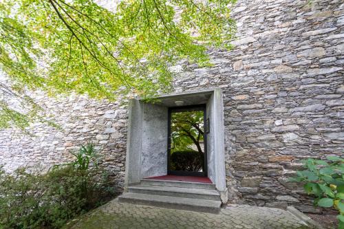 a window in a stone building with a red door at Castello Ripa Baveno in Baveno