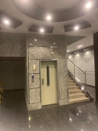 a lobby with a door and stairs in a building at Orchid Tarif Serviced Apartments 1 شقق أوركيد طريف للشقق المخدومة 1 in Ţurayf