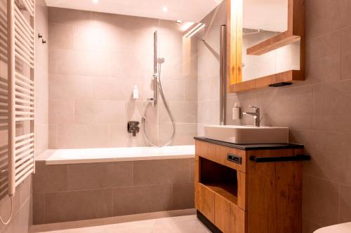 y baño con ducha, lavabo y bañera. en All-Suite Resort Zwieselstein - Sölden en Sölden