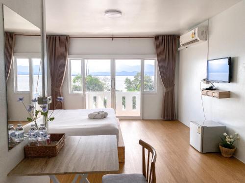 um quarto com uma cama, uma mesa e uma televisão em ฤกษ์ดี RerkDee bed and Breakfast em Phayao