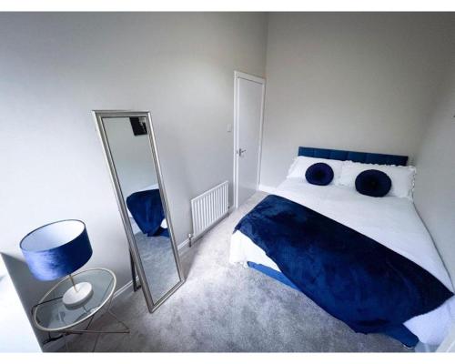 a bedroom with a large bed and a mirror at Strudel House - Luxury 1 Bed Apartment in Aberdeen City Centre in Aberdeen