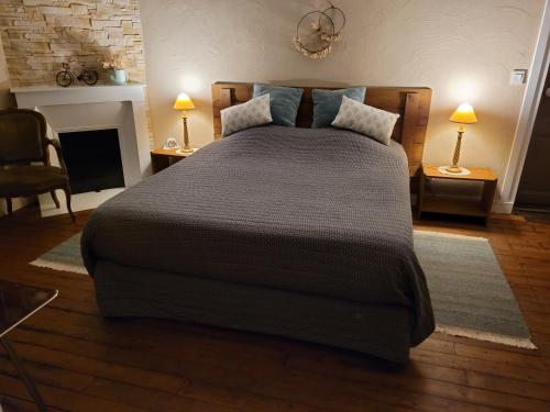sypialnia z dużym łóżkiem i kominkiem w obiekcie Le Panoramique w mieście Auvers-sur-Oise