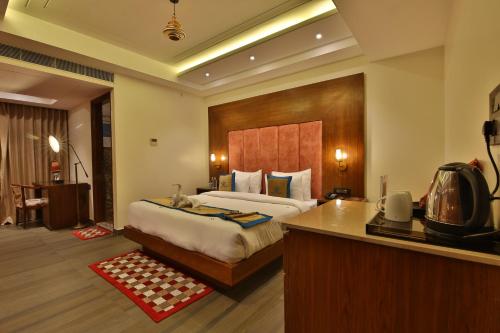 a hotel room with a bed and a kitchen in it at Hotel Holy Vivasa in Rishīkesh