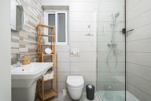La salle de bains est pourvue d'une douche, de toilettes et d'un lavabo. dans l'établissement Spacious, Modern & Cosy 2 Bedroom 2 Bathroom Apartment - St. Julians, à San Ġiljan