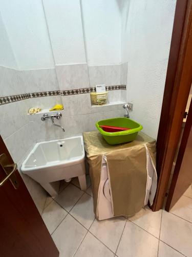 a bathroom with a sink and a green bowl on a counter at La casa sotto la torre in Chia