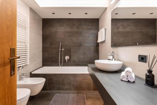 een badkamer met 2 wastafels en een bad bij Villa Erina App D2 in Ortisei