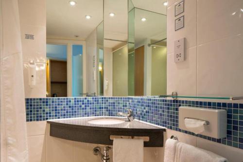 a bathroom with a sink and a mirror at Holiday Inn Express Doncaster by IHG in Doncaster