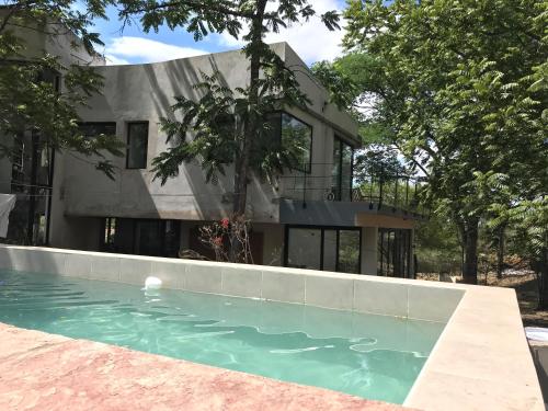 uma casa com piscina em frente a uma casa em La Nube - San Lorenzo em San Lorenzo