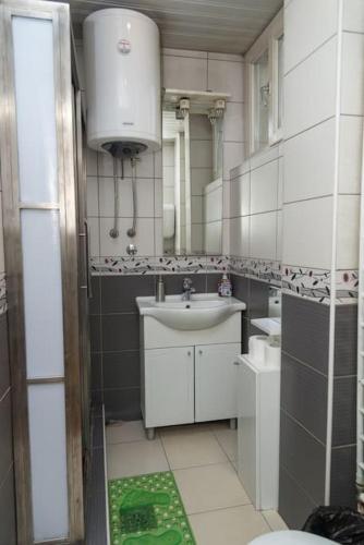 a bathroom with a sink and a toilet and a mirror at Apartman Panorama Glavna ulica in Užice