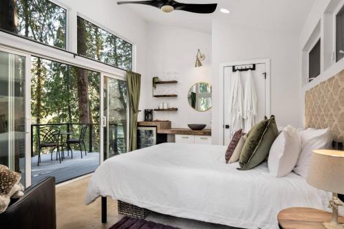 1 dormitorio con cama blanca y balcón en The Cedars at Rivers Edge, en West Linn