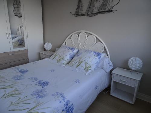 - une chambre avec un lit orné de fleurs bleues dans l'établissement Résidence Port an Dro, à Carnac-Plage