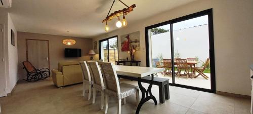 une salle à manger et un salon avec une table et des chaises dans l'établissement Bleu Soleil, à Hauteville-sur-Mer