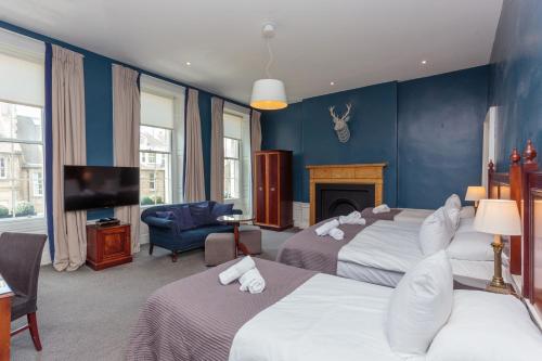a hotel room with two beds and a tv at No. 53 Frederick Street in Edinburgh