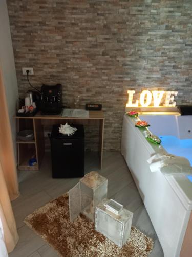 a room with a couch and a table with a love sign at Mary Gery's Rooms in Castellammare del Golfo