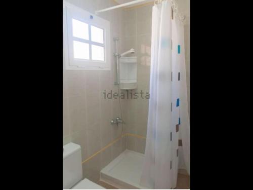 a bathroom with a shower and a toilet and a window at Alojamientos Vistas Edén 67 in Caleta De Fuste