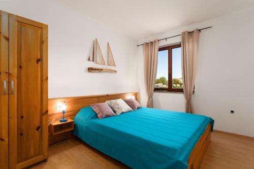 Un dormitorio con una cama azul y una ventana en Holiday apartment KALIĆ, en Štokovci