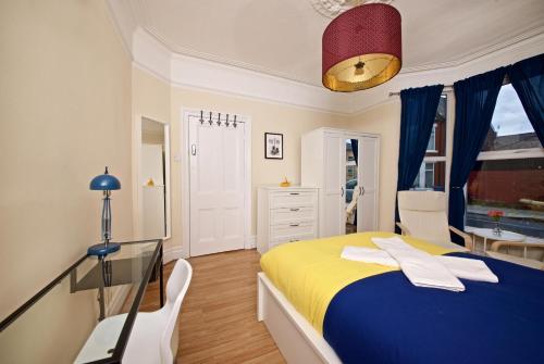 a bedroom with a blue and yellow bed and a desk at Liverpool City Stays - The Beatles Theme House - Penny Lane DD1 in Liverpool