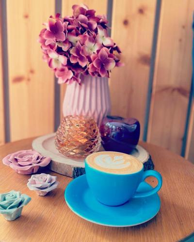 a table with a cup of coffee and a vase with flowers at Sousedi Pavlov in Pavlov