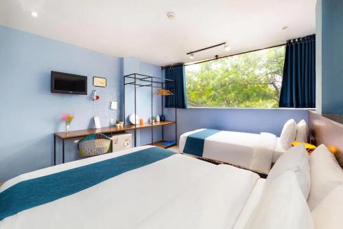 a bedroom with two beds and a window at Hoàng Phi Hotel in Ho Chi Minh City
