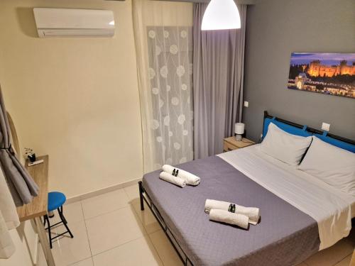 comfy center rodos - sweethome في Asgourou: غرفة نوم عليها سرير وفوط