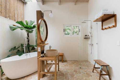a bathroom with a tub and a sink and a mirror at Casa Arena Beachfront Property in Santa Teresa Beach