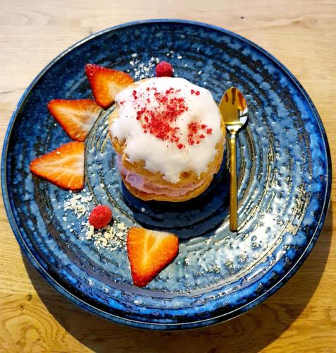 a blue plate with a doughnut with strawberries on it at Sousedi Pavlov in Pavlov