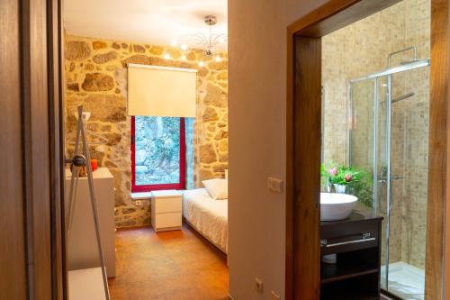 łazienka z łóżkiem i umywalką w pokoju w obiekcie Casa das Castanhas - near Gerês w mieście Braga