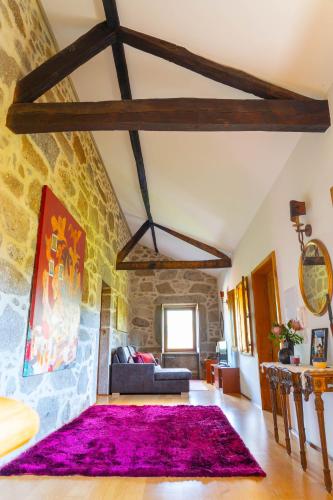 a living room with a purple rug on the floor at Casa das Castanhas - near Gerês in Braga