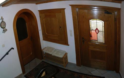 a bathroom with wooden cabinets and a door at Haus Klammtal in Schwendau