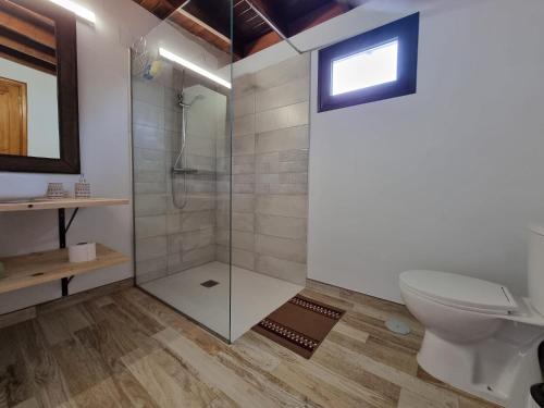 a bathroom with a shower and a toilet at Alunita & Pirita, Habitación con Jardín, Terraza y WiFi en zona tranquila y céntrica in Nazaret