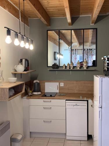 uma cozinha com armários brancos e um frigorífico branco em Duplex terrasse em Frehel
