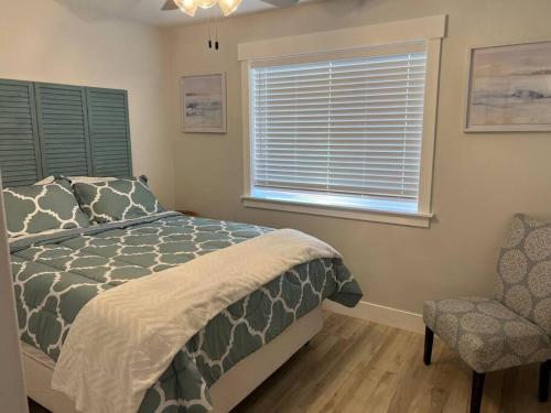a bedroom with a bed and a chair and a window at Heritage Suites 1998 #4- Peaceful 1 bedroom 1 bath Suite in Idaho Falls
