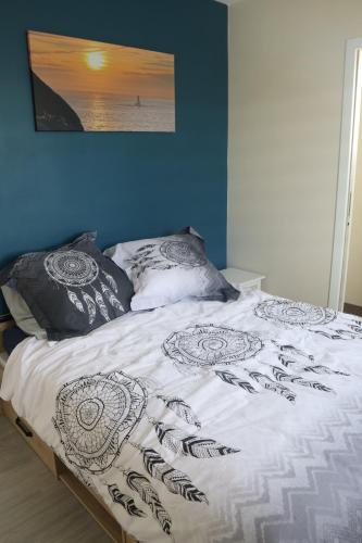 - un lit avec des draps et des oreillers en noir et blanc dans l'établissement Ty Enez Mor, à Lanildut