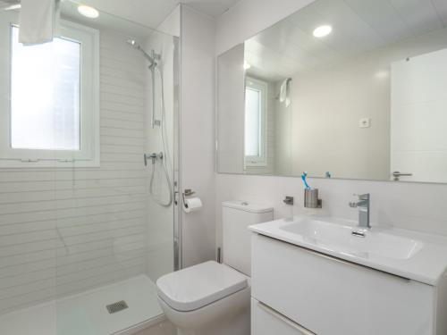 Baño blanco con aseo y lavamanos en Via Celere 2344, en Casares