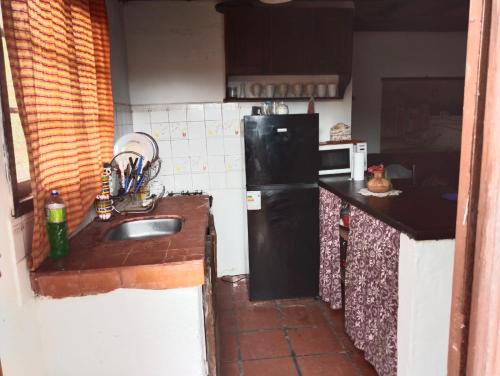 a kitchen with a sink and a black refrigerator at Nalu in La Paloma