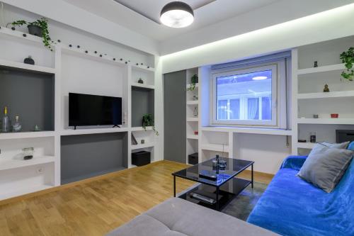 a living room with a blue couch and a tv at Kolonaki Suite in Athens in Athens