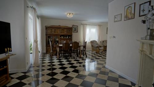 uma sala de jantar com uma mesa e um piso em xadrez em Willa Raj - Apartamenty nad jeziorem KA-BOATS em Rajgród