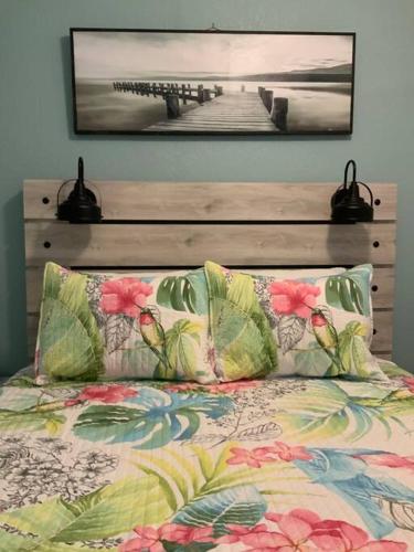 a bed with two pillows and a wooden head board at Cozy Coastal Beach Retreat in Clearwater Beach