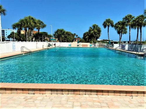 a large pool of blue water with palm trees at Comfy Coastal Beach Vacation in Clearwater Beach