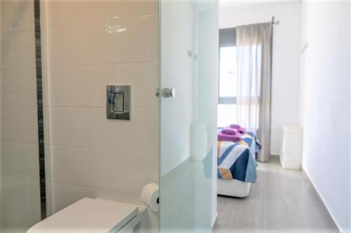 uma casa de banho com chuveiro e uma cama num quarto em Fantastic 2 bed apartment in modern complex in Pilar de la Horadada em Pilar de la Horadada