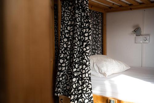 a bedroom with a bed with a black and white curtain at Drago Hostel in Icod de los Vinos