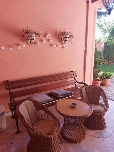a patio with a bench and two chairs and a table at Apartman Dane in Kikinda