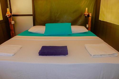 a bed with a blue laptop on top of it at Yala Dream Park in Yala