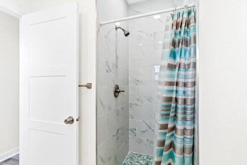 El baño incluye ducha con cortina de ducha a ras de suelo. en Dolphin Watch en Clearwater Beach